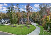 Stunning brick home featuring mature trees, a lush green lawn, and a winding driveway in a beautiful wooded setting at 4071 Poplar Ridge Dr, Fort Mill, SC 29715