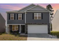 Charming two-story home with gray siding, stone accents, and a two-car garage for convenient parking at 4538 Opus Ln, Charlotte, NC 28214