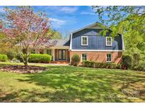 Charming two-story home with a brick facade and a well-manicured lawn, complemented by mature trees at 4937 Broken Saddle Ln, Charlotte, NC 28226