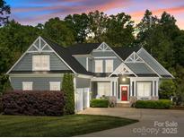 Charming two-story home with gray siding, white trim, a red front door, and a well-manicured front yard at 6743 Fox Ridge Cir, Davidson, NC 28036