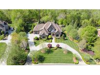 Stunning aerial view of an estate home with lush landscaping and a circular driveway nestled among mature trees at 1012 Shippon Ln, Waxhaw, NC 28173
