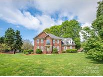 Stunning brick home with well-manicured front lawn and mature trees, offering classic elegance and curb appeal at 126 Pointer Se Ct, Concord, NC 28025
