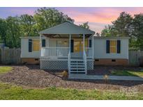 Charming single-story home features a cozy front porch perfect for enjoying peaceful evenings at 140 Misty Ln, Rockwell, NC 28138