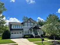 Charming two-story home with landscaped yard, gray siding and white trim, plus attached two-car garage at 1550 Matthew Mcclure Cir, Davidson, NC 28036