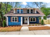 Charming blue two-story home with brown shutters and a well-manicured lawn offers great curb appeal at 166 Franklin Nw Ave, Concord, NC 28025