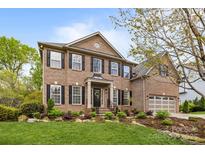 Beautiful brick home with manicured lawn and mature landscaping; a welcoming front entrance at 1809 Robbins Meadows Dr, Waxhaw, NC 28173
