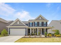 Charming two-story home with a well-manicured lawn, inviting front porch, and attached two-car garage at 235 Boxelder Rd, Clover, SC 29710