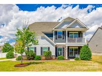 Charming two-story home with a well-manicured lawn, stone accents, and inviting front porch and balcony at 4013 Highgate Ln # 2B-78, Lancaster, SC 29720