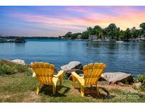 Stunning waterfront view with two yellow chairs and colorful sky at 7829 Village Harbor Dr, Cornelius, NC 28031