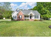Inviting single-Gathering home showcasing manicured lawn, gray siding, and charming brick accents for classic curb appeal at 921 Snow Prince Ln, York, SC 29745