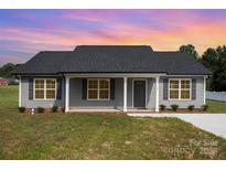 Charming single-story home featuring gray siding, a dark shingle roof, and a well-maintained front lawn at 115 Frances St, Salisbury, NC 28147