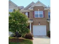 Charming brick townhome featuring a well-maintained lawn and an attached one-car garage at 14022 Drake Watch Ln, Charlotte, NC 28262
