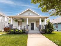 Charming home with a welcoming porch, swing, and well-maintained landscaping at 1561 Wilmore Dr, Charlotte, NC 28203