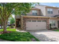 Charming townhome featuring a stone facade, two-car garage, and beautifully landscaped front yard at 2001 Cramer Place Ct, Cramerton, NC 28032