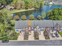 Stunning aerial view of townhomes with a scenic lake backdrop, lush greenery, and well-manicured lawns at 4011 Fenworth Ct, Fort Mill, SC 29715