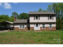 Charming two-story home with a lovely front lawn and a covered carport on a sunny day at 5915 Bluebonnet Rd, Charlotte, NC 28212