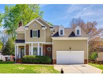 Charming two-story home with a manicured lawn, attached garage, and brick detailing under blue skies at 609 Tysons Forest Dr, Rock Hill, SC 29732