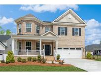 Beautiful two-story brick home featuring a welcoming front porch and well-manicured lawn at 620 Baneberry Bluff Ct, Rock Hill, SC 29732