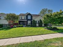 Charming two-story home featuring a well-maintained lawn and beautifully landscaped front yard with mature trees at 8140 Laurel Run Dr, Charlotte, NC 28269