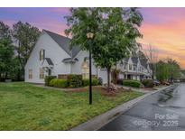 Charming home with manicured lawn, mature tree, and lamp post at sunset at 942 Pelican Bay Dr, Pineville, NC 28134