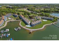 Stunning aerial view of lakeside condos with mature trees, boat docks, and lovely green spaces at 1211 Torrence Cir, Davidson, NC 28036