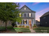 Charming two-story home featuring a welcoming front porch, landscaped lawn, and a classic design at 13813 Jacks Ln, Pineville, NC 28134