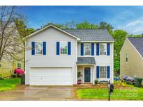 Charming two-story home featuring white siding, blue shutters, attached garage, and landscaped front yard at 1581 Arborgate Dr, Rock Hill, SC 29732