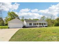 Charming single-story home featuring a spacious front yard and a detached two-car garage at 1676 Starmount Cir, Lancaster, SC 29720