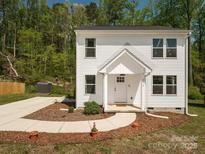 Charming two-story home with white siding, well-manicured landscaping, and a welcoming front porch at 2313 Glenwood St, Kannapolis, NC 28083