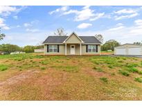 Charming single-story home featuring a classic design, manicured lawn, and a detached two-car garage at 391 Springs East Rd, Lincolnton, NC 28092