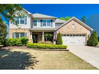 Charming two-story home featuring brick and vinyl siding, lush landscaping, and a welcoming two-car garage at 4032 Wild Turkey Ln, Indian Land, SC 29707
