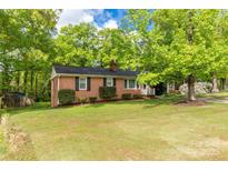 Charming brick home featuring a well-manicured lawn and lush trees creating a serene curb appeal at 510 N Jackson Rd, Lancaster, SC 29720