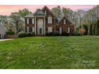 Traditional brick home with well-maintained lawn, blue shutters and mature trees at 591 Highland Ridge Rd, Mooresville, NC 28115