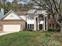 Charming two-story home featuring a brick facade, white columns, a green front door, and a well-maintained lawn at 6112 Swanston Dr, Charlotte, NC 28269
