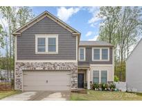 Charming two-story home features a stone and shingle facade, attached garage, and well-maintained landscaping at 710 Anglin Forest Way, Charlotte, NC 28214