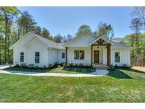 Charming single-story home featuring a beautifully landscaped front yard and inviting entrance with natural wood accents at 8225 Long Island Rd, Catawba, NC 28609