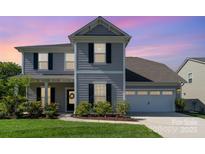 Charming two-story home with gray siding, black shutters, a two-car garage, and a manicured front lawn at 1003 Dorsey Dr, Fort Mill, SC 29715