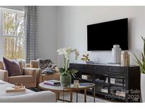 Cozy living room showcasing a black entertainment center, neutral furniture, and a stylish round coffee table at 2108 Endeavor Run, Charlotte, NC 28269