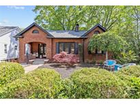 Charming brick home featuring manicured landscaping, black shutters, and inviting front porch at 2125 Kenilworth Ave, Charlotte, NC 28203