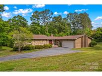 Spacious single-story home featuring stone and brick, an attached garage, and a well-maintained lawn at 2281 Old Salisbury Concord Rd, Concord, NC 28025