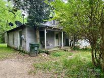 Exterior view of a home with a covered porch and mature trees at 267 Hall Nw Ave, Concord, NC 28027