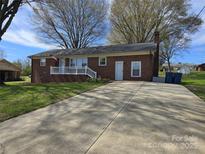 Charming single-story brick home with a spacious driveway and inviting front porch at 3025 School St, Claremont, NC 28610