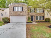 Traditional brick home featuring an attached two-car garage and a well-maintained front lawn at 3227 Deshler Morris Ln, Charlotte, NC 28216