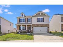 Charming two-story home featuring a covered porch, two-car garage, and well-maintained lawn on a sunny day at 3286 Shining Rock Sw St, Concord, NC 28027