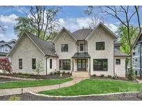 Elegant two-story home showcasing a beautiful brick exterior, manicured lawn and walkway at 438 Wonderwood Dr, Charlotte, NC 28211