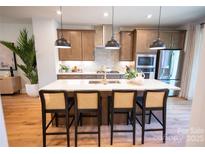 Bright eat-in kitchen featuring a large island with barstool seating and pendant lighting at 451 Old Town Village Rd, Waxhaw, NC 28173
