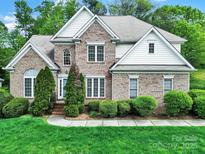 Charming two-story brick home with manicured lawn and mature trees in a desirable neighborhood at 7935 Harrington Woods Rd, Charlotte, NC 28269