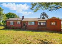 Charming brick home featuring a well-maintained lawn and mature trees at 8408 Mcclure Cir, Charlotte, NC 28216