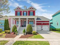 Charming two-story red home with a spacious front porch and well-manicured landscaping at 9636 Cotton Stand Rd, Charlotte, NC 28277