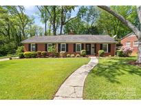 Charming brick home with a manicured front yard, walkway and mature trees at 4626 Fairbluff Pl, Charlotte, NC 28209